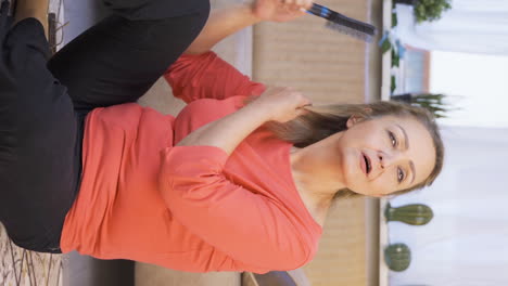 Vertical-video-of-Woman-combing-her-hair.